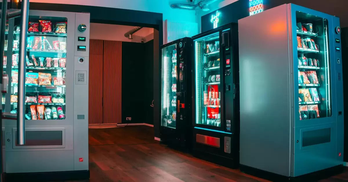 Das Bild zeigt den Blick von der Eingangstür ins innere des Laden. Es sind verschiedene Automaten von SandenVendo und Sielaff zu sehen und deren Wareninhalte.